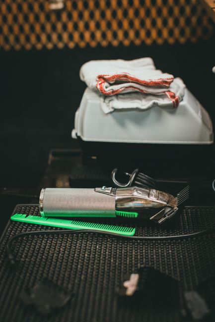 Clipper and comb laid out on a barber station